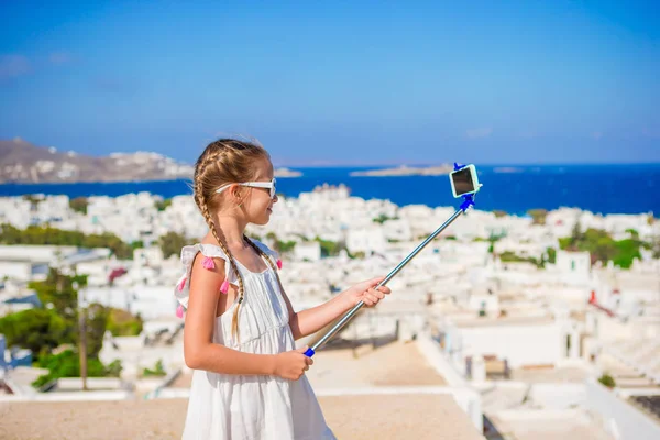 Liten flicka tar selfie bakgrund Mykonos stad i Grekland — Stockfoto
