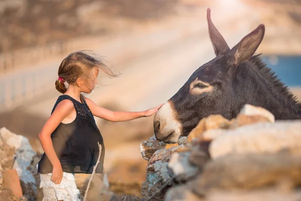 Mykonos adasında eşekli küçük bir kız. — Stok fotoğraf