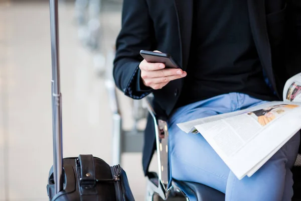 Gros plan téléphone portable entre les mains des hommes à l'aéroport en attendant l'embarquement . — Photo