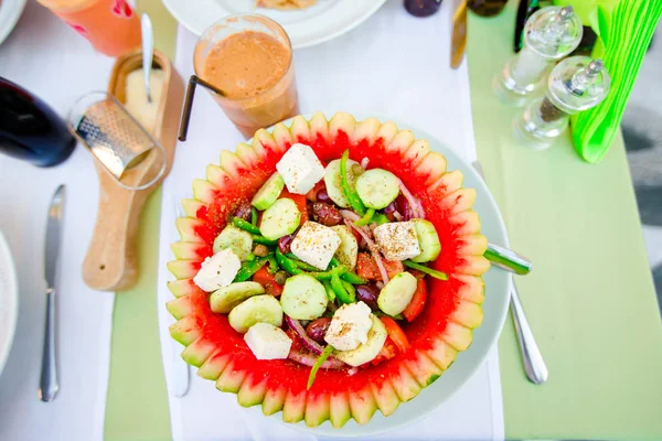 Pyszne świeże sałatki greckiej serwowane w porze lunchu w arbuza w restauracji na świeżym powietrzu — Zdjęcie stockowe