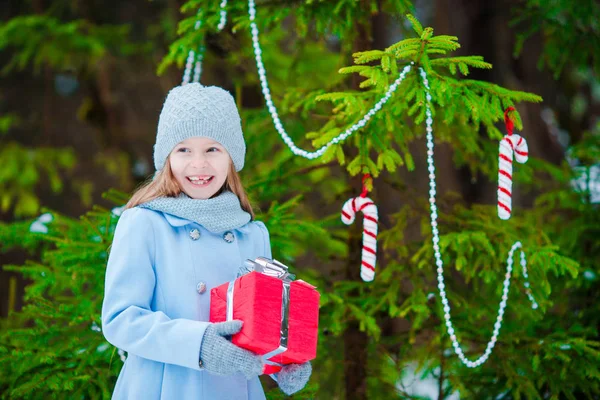 Adorable girl with christmas box gift in winter outdoors on Xmas eve — Stock Photo, Image