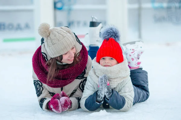 Porträtt av lilla bedårande flickan med sin mamma som skridskoåkning — Stockfoto