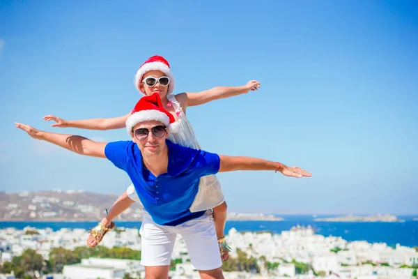 Kleines Mädchen und glücklicher Papa in Weihnachtsmützen genießen Weihnachtsurlaub mit schöner Aussicht — Stockfoto