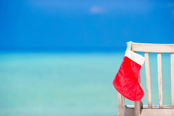 Santa Claus Sock on chair near tropical beach with turquoise sea water and white sand. Christmas vacation concept — Stock Photo, Image