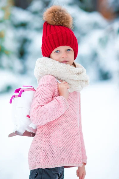 Adorable petite fille qui va patiner sur la patinoire en hiver jour de neige — Photo