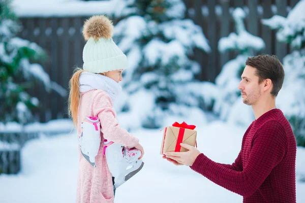 Junger Vater macht seiner kleinen entzückenden Tochter ein Weihnachtsgeschenk — Stockfoto