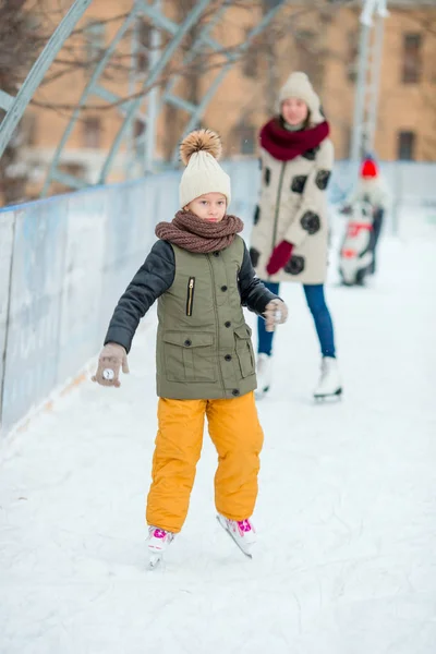 Schattig meisje schaatsen op de ijsbaan buitenshuis — Stockfoto