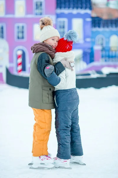 Adorable little girls skating on the ice rink outdoors — Stock Photo, Image