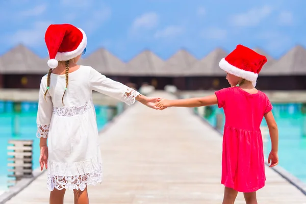 Kleine meisjes in rode hoeden tijdens kerstvakantie — Stockfoto