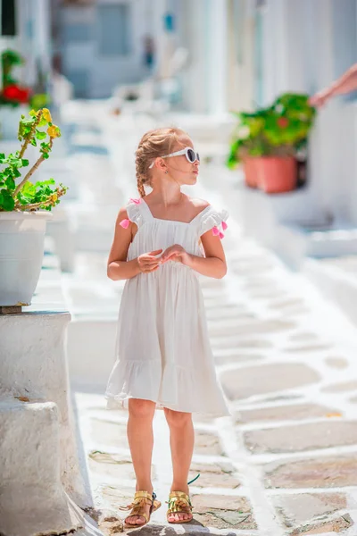 Niña al aire libre en la vieja aldea griega. Niño en la calle del típico pueblo tradicional griego con paredes blancas y puertas coloridas en Mykonos —  Fotos de Stock