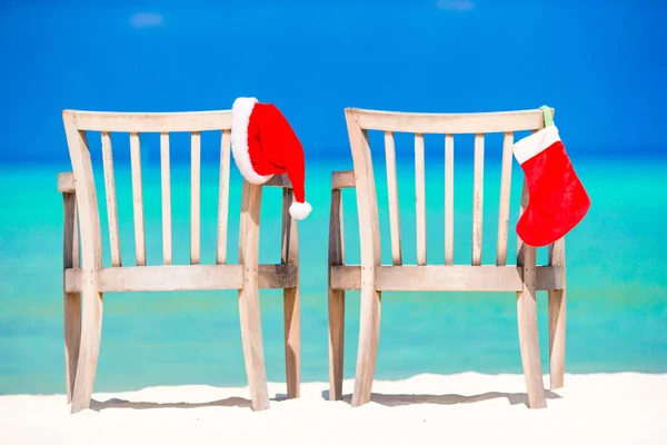 Natal em cadeiras de praia em café com chapéus de Papai Noel no mar — Fotografia de Stock