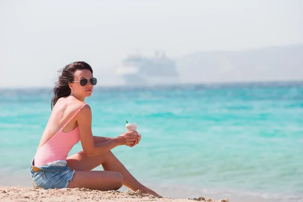 Joven hermosa mujer con café en la playa durante las vacaciones tropicales. — Foto de Stock