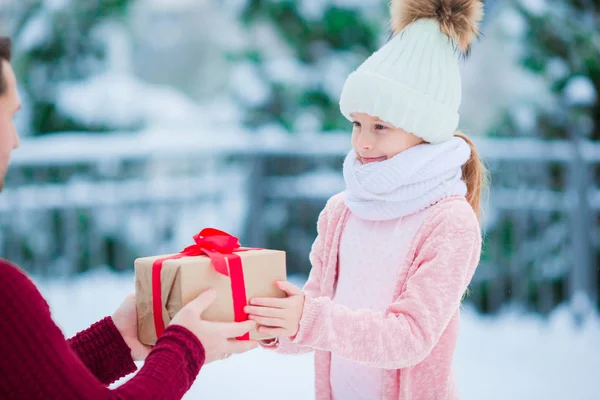 Familie met de gift van Kerstmis op Xmas eve buitenshuis — Stockfoto