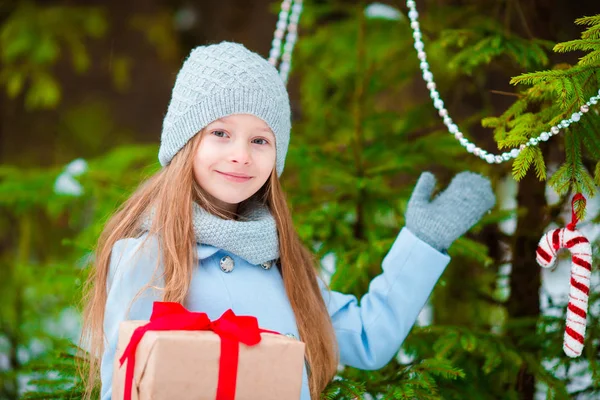 Adorable girl with christmas box gift in winter outdoors on Xmas eve — Stock Photo, Image