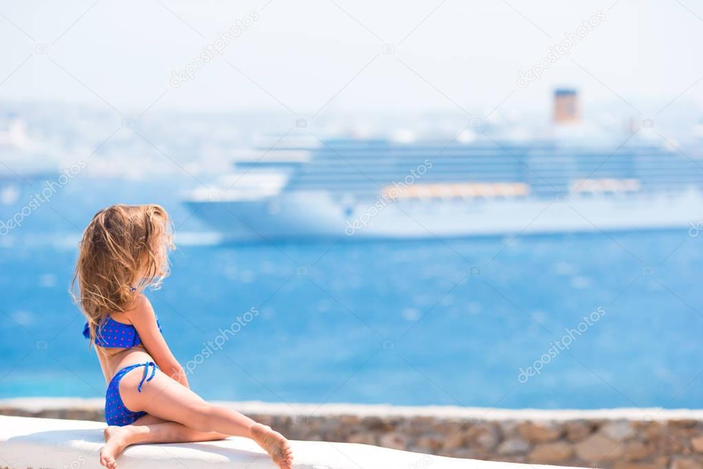 Adorable little girl background big liner in Mediterranean sea