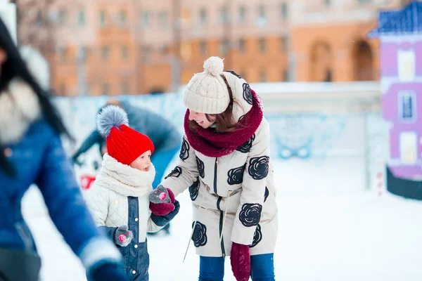 Kleines entzückendes Mädchen mit ihrer Mutter beim Schlittschuhlaufen auf der Eisbahn — Stockfoto