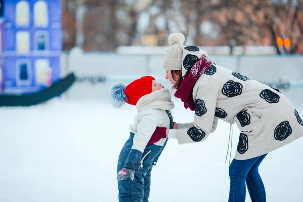 Porträt eines kleinen entzückenden Mädchens und einer jungen Mutter beim Eislaufen — Stockfoto