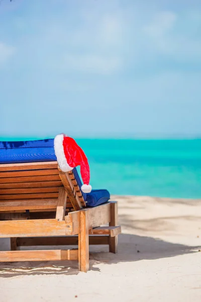 Kerstman hoed op strand ligbed met turquoise zeewater en wit zand. Kerst vakantie concept — Stockfoto