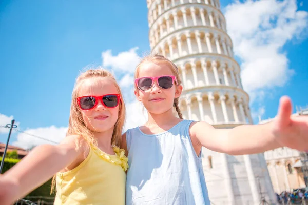 Małe dziewczynki turystów biorąc selfie tło krzywej wieży w Pizie, Włochy. Zdjęcie o europejskie wakacje — Zdjęcie stockowe