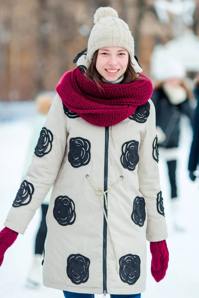 Happy young woman skating on ice rink outdoors — Stock Photo, Image