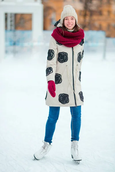 Gelukkig jong meisje schaatsen op de ijsbaan buitenshuis — Stockfoto