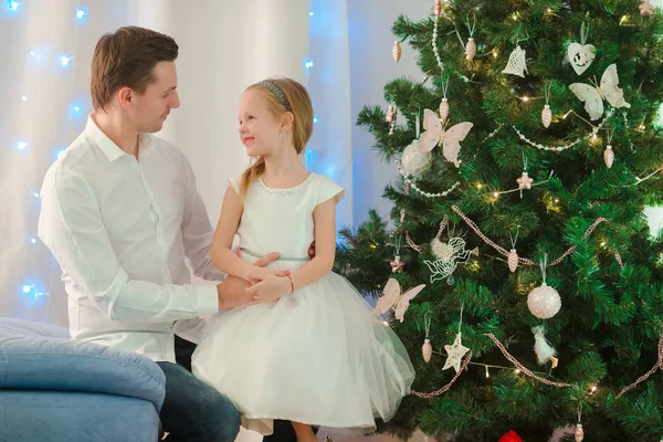 Pai com pequena menina bonita perto da árvore de Natal na véspera de Natal — Fotografia de Stock