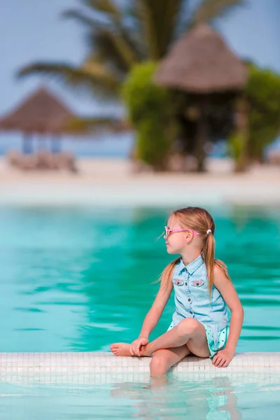 Pequena menina adorável feliz na borda da piscina exterior — Fotografia de Stock