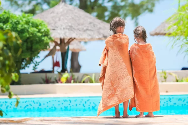 Adorable little girls wrapped in towel on the edge of pool — Stock Photo, Image