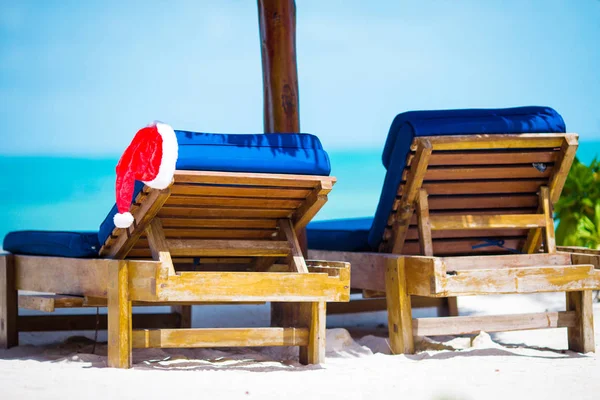 Chapéu de Pai Natal na espreguiçadeira da praia. Conceito de férias de Natal — Fotografia de Stock