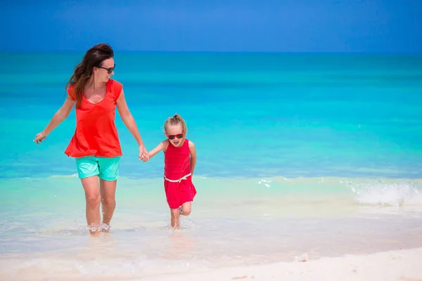 Matka a malá dcerka těší čas na tropické pláži — Stock fotografie