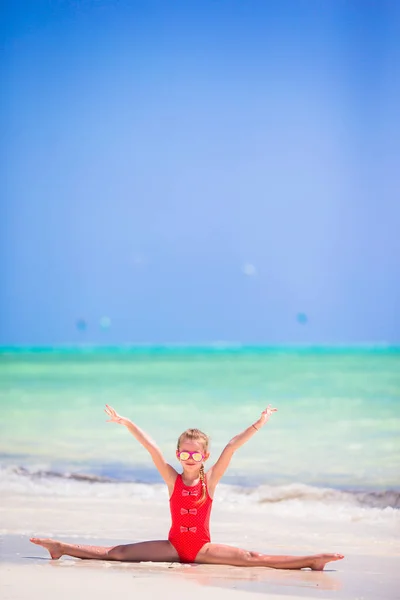 Маленькая девочка на белом пляже веселится — стоковое фото