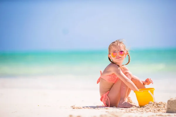 Adorable niña jugando con juguetes de playa en la playa blanca —  Fotos de Stock