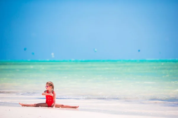 Sporty adorable little girl on white beach having fun — Stock Photo, Image