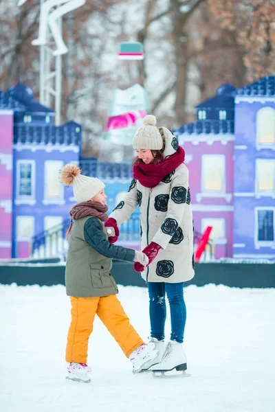 Little adorable girl skating on ice-rink with mother — Stock Photo, Image