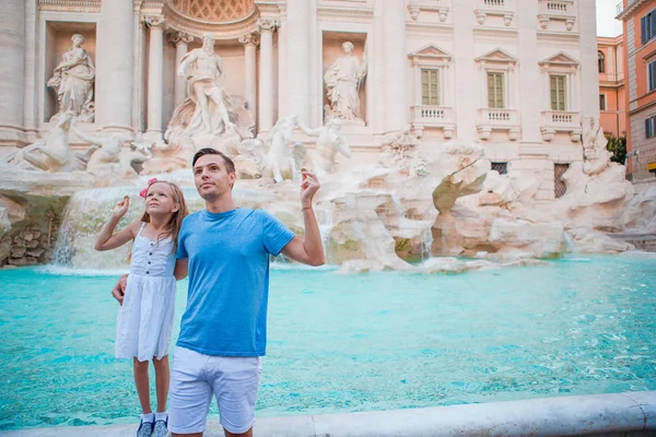 Bonne famille troquant des pièces à la fontaine de Trevi, Rome, pour bonne chance. Petite fille et père faisant le vœu de revenir . — Photo