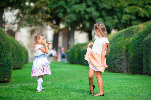 Little adorable girls outdoors at summer time on european vacation in the garden of the Tuileries — Stock Photo, Image
