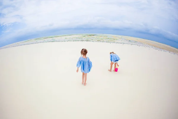 Rozkošný šťastné malé holčičky se bavit v mělké vodě na pláži dovolenou — Stock fotografie