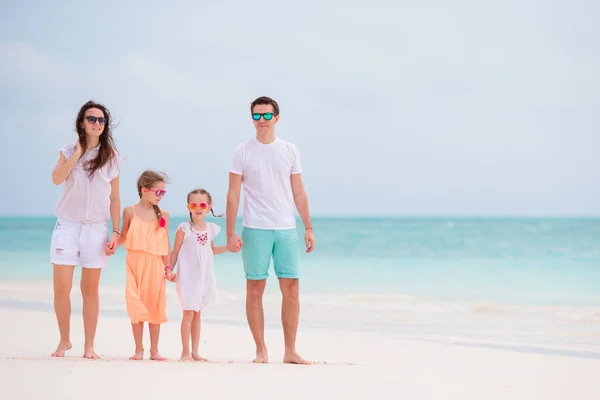 夏休みの間に熱帯のビーチで一緒に歩く子供たちと幸せな美しい家族 — ストック写真