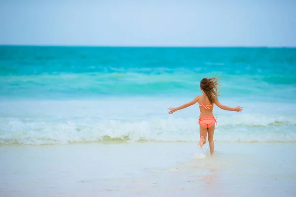 Маленькая девочка на пляже во время летних каникул — стоковое фото