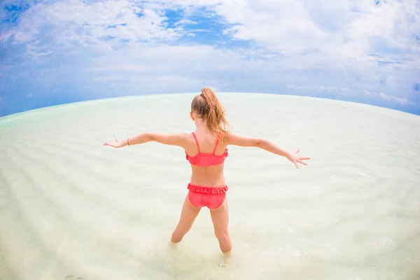 Adorable niña feliz divertirse en aguas poco profundas en vacaciones de playa —  Fotos de Stock