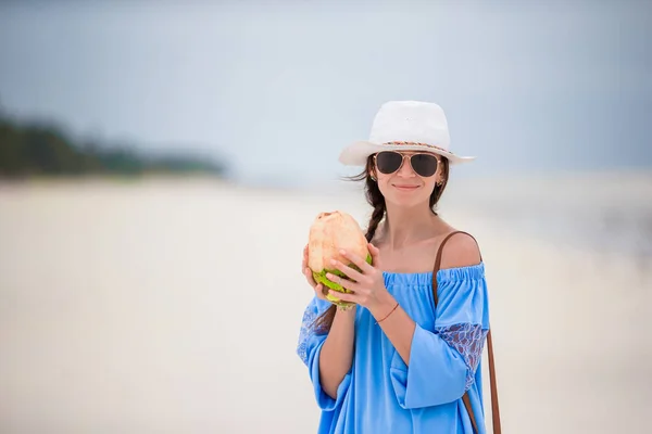 Mujer joven con coco en la playa vacía blanca — Foto de Stock