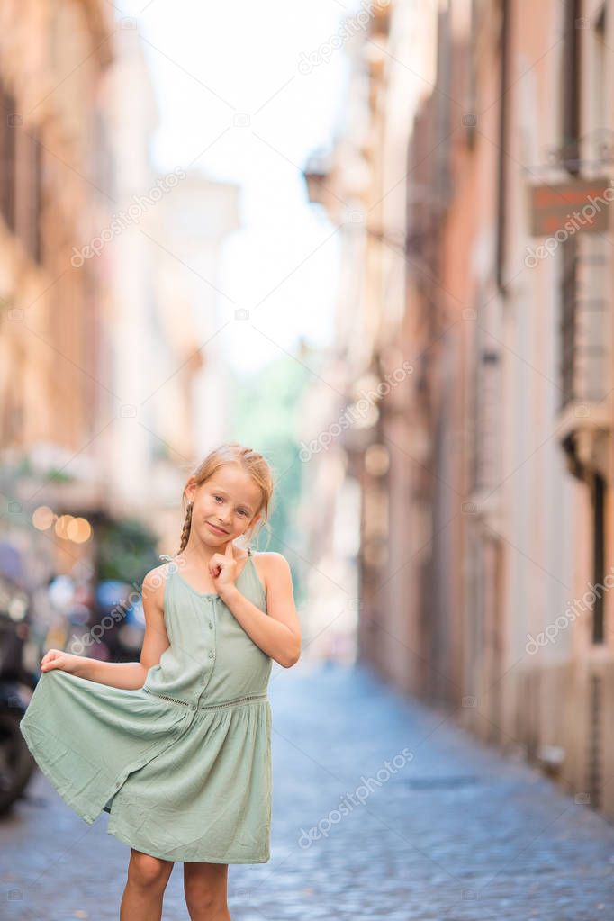 Adorable happy little girl outdoors in european city. Portrait of caucasian kid enjoy summer vacation in Rome