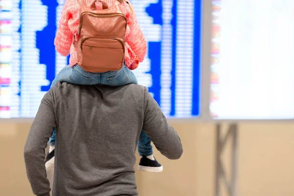 Babasının havaalanındaki uçuş bilgilerine sahip küçük bir kız. — Stok fotoğraf
