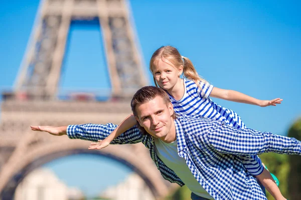 Happy family in Paris near Eiffel Tower during summer french vacation