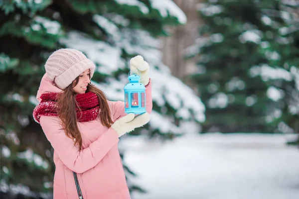 Krásná žena držící Vánoční svíčky venku na krásné zimní sníh den — Stock fotografie