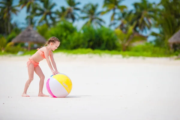 Linda niña jugando con la pelota en la playa, los niños deporte de verano al aire libre — Foto de Stock