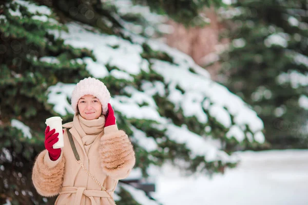 Mooi meisje met koffie naar buiten op de mooie winterdag sneeuw — Stockfoto