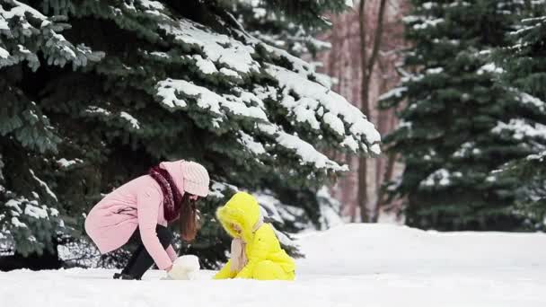 Happy mother and kid enjoy winter snowy day and playing snowballs — Stock Video