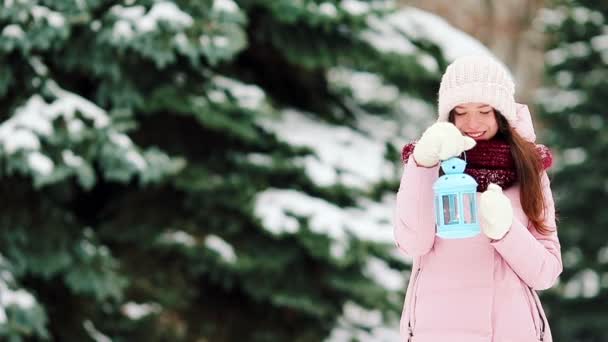 Young woman holding Christmas candlelight outdoors on beautiful winter snow day — Stock Video