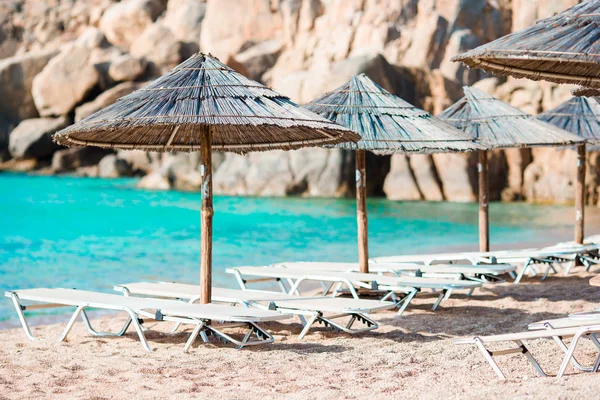 Beach wooden chairs and umbrellas for vacations on beach in Greece — Stock Photo, Image